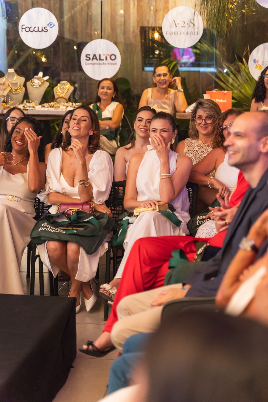 Convidadas rindo na plateia durante uma edição anterior do Encontro Anual.