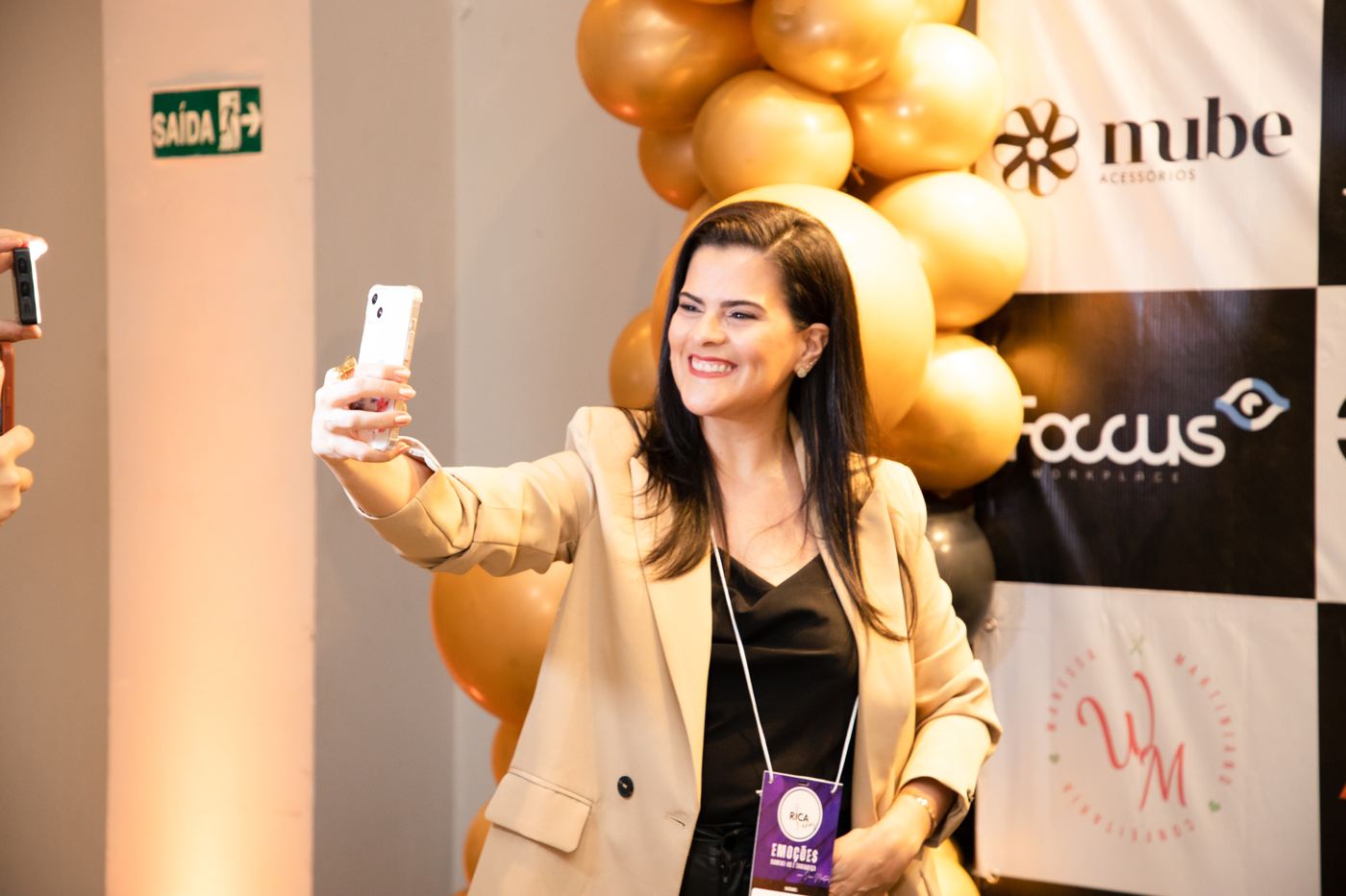 Participante de blazer tirando uma selfie no Encontro.